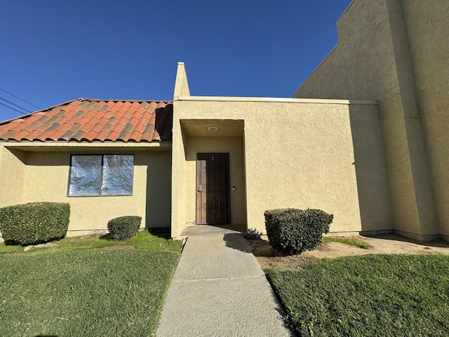 doorway to property with a yard