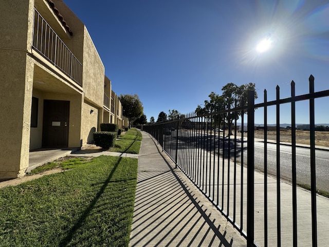 view of gate with a lawn