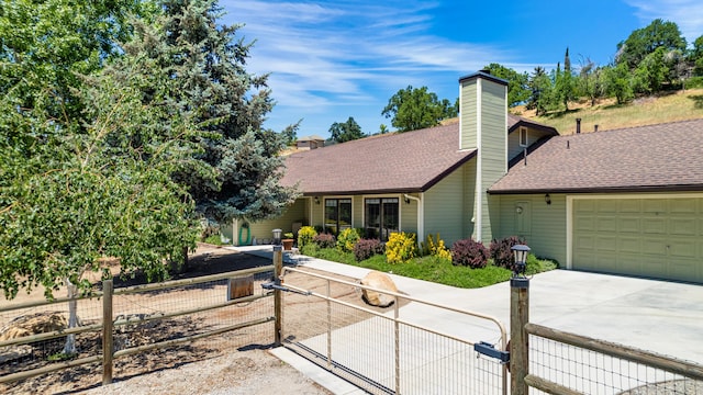 24140 Deertrail Dr, Tehachapi, CA 93561 - view of front of property featuring a chimney, an attached garage, driveway, and roof with shingles