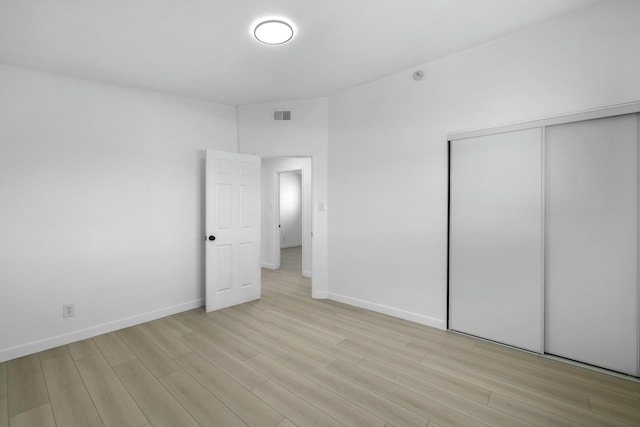 unfurnished bedroom featuring a closet and light hardwood / wood-style floors