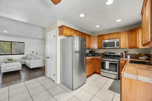 kitchen with light tile patterned flooring, appliances with stainless steel finishes, and sink