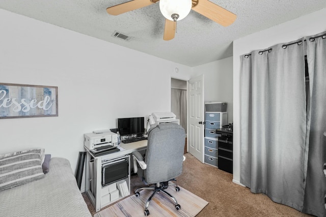 carpeted office with ceiling fan and a textured ceiling