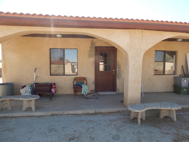 view of exterior entry featuring a patio area