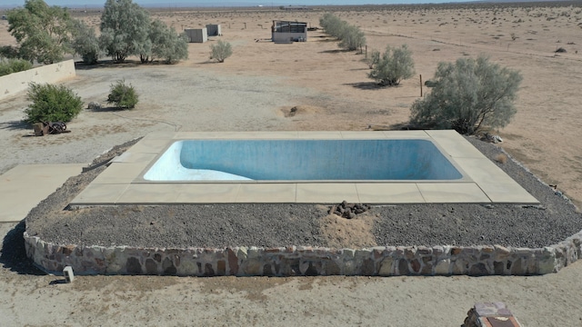 view of swimming pool featuring a rural view