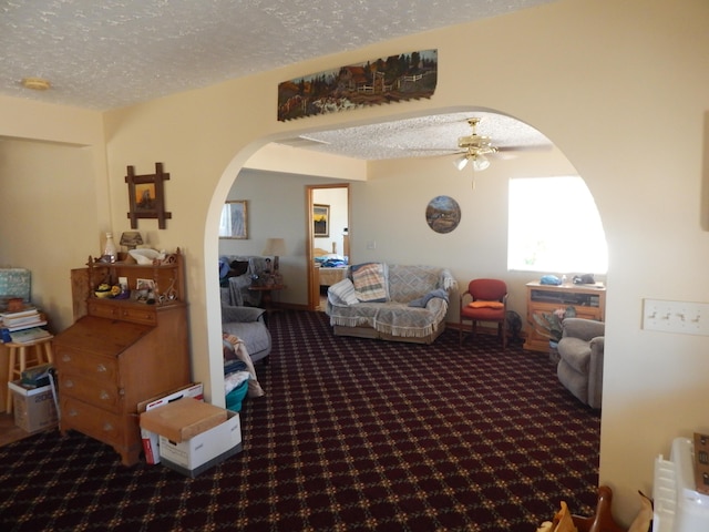 carpeted living room featuring a textured ceiling and ceiling fan