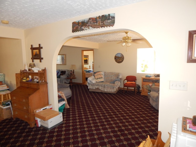 carpeted living room with ceiling fan and a textured ceiling