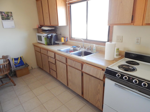 kitchen with white appliances, sink, and light tile patterned floors