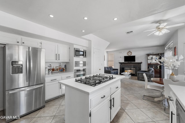 44559 Aspen St, Lancaster, CA 93535 - kitchen with appliances with stainless steel finishes, light countertops, a glass covered fireplace, light tile patterned flooring, and recessed lighting