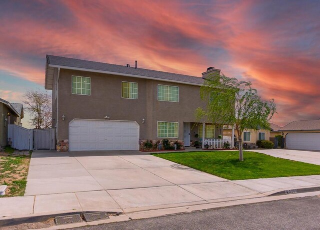 view of front of home featuring stucco siding, driveway, a gate, a garage, and a yard