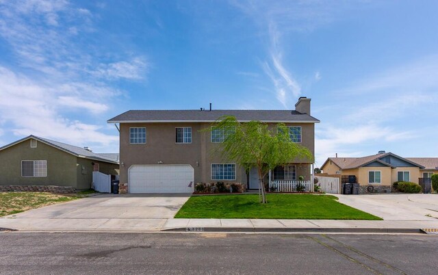 view of front of property with concrete driveway, stucco siding, fence, a front yard, and a garage
