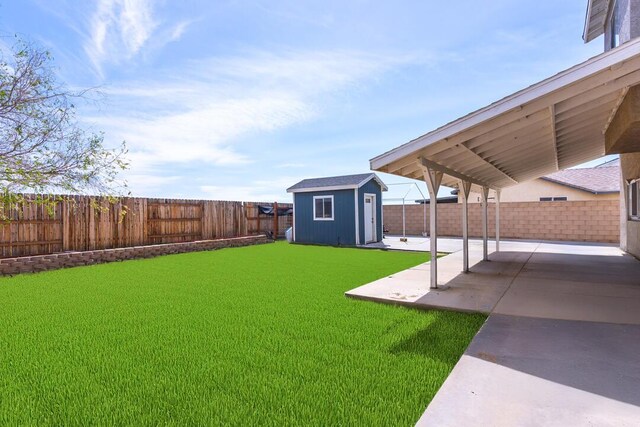 view of yard with an outdoor structure, a fenced backyard, a storage shed, and a patio area