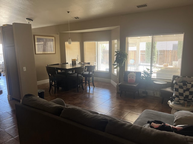 tiled living area featuring baseboards and lofted ceiling