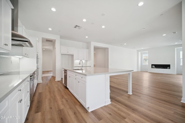 3716 Eliopulos Ranch Dr, Palmdale, CA 93551 - kitchen with light wood finished floors, wall chimney range hood, white cabinets, recessed lighting, and dishwasher