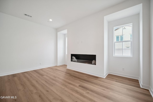 3716 Eliopulos Ranch Dr, Palmdale, CA 93551 - unfurnished living room featuring light wood-style floors, a glass covered fireplace, and recessed lighting