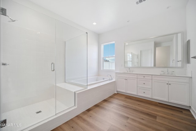 3716 Eliopulos Ranch Dr, Palmdale, CA 93551 - bathroom featuring wood finished floors, a garden tub, double vanity, a shower stall, and recessed lighting