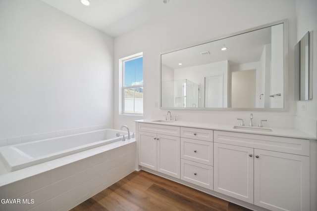 3716 Eliopulos Ranch Dr, Palmdale, CA 93551 - bathroom featuring double vanity, a garden tub, wood finished floors, a shower with shower door, and recessed lighting