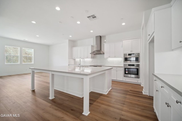 3716 Eliopulos Ranch Dr, Palmdale, CA 93551 - kitchen with wall chimney range hood, stainless steel double oven, recessed lighting, decorative backsplash, and white cabinetry
