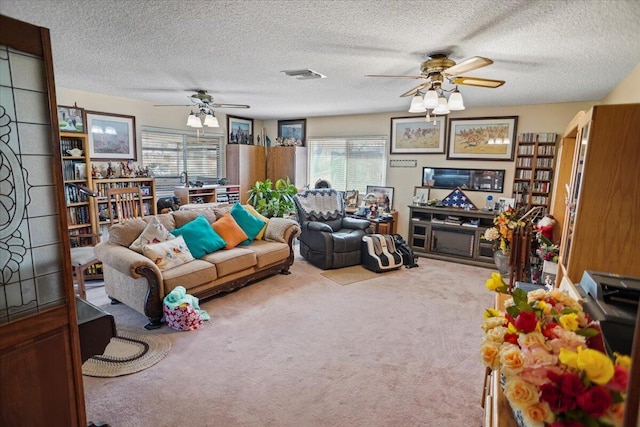 carpeted living room featuring visible vents, a textured ceiling, and a ceiling fan