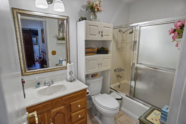 full bath with vanity, tile patterned floors, toilet, and combined bath / shower with glass door