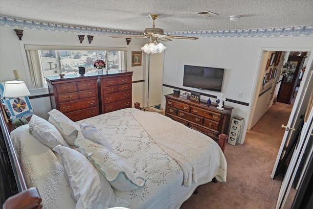 carpeted bedroom with visible vents, a textured ceiling, and ceiling fan