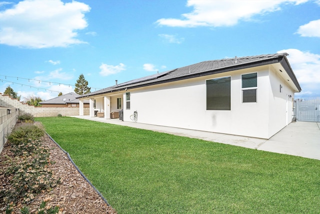 rear view of property featuring a patio and a lawn