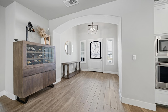 entryway with a chandelier and light wood-type flooring