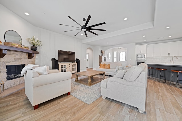 living room with sink, a fireplace, and ceiling fan