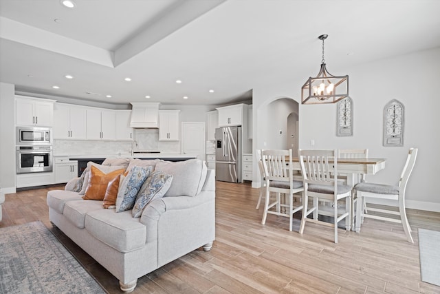 living room featuring a chandelier and light hardwood / wood-style flooring