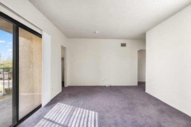 unfurnished room featuring a textured ceiling and carpet flooring