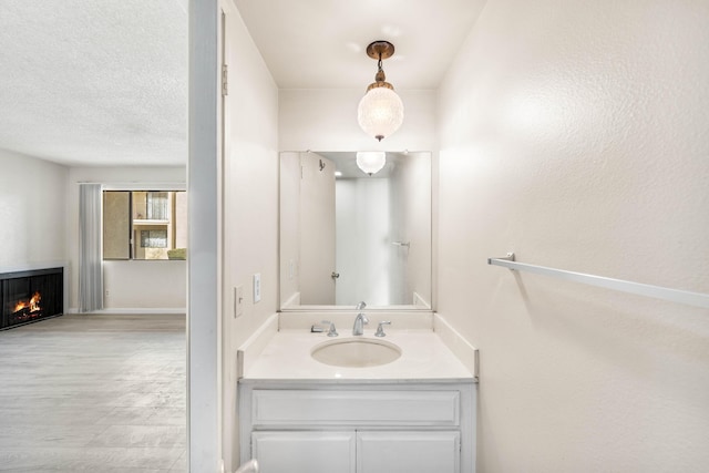 bathroom featuring vanity, hardwood / wood-style floors, and a textured ceiling