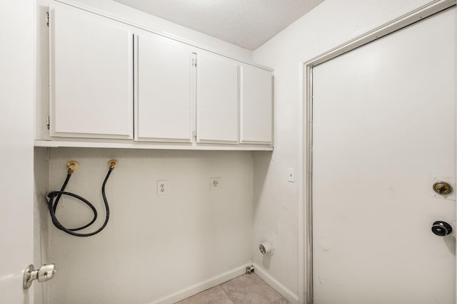 laundry room with cabinets, a textured ceiling, light tile patterned floors, hookup for a washing machine, and electric dryer hookup