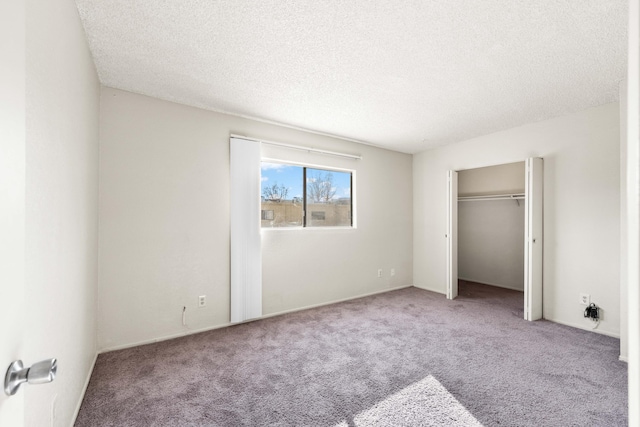 unfurnished bedroom featuring a closet, a textured ceiling, and carpet flooring