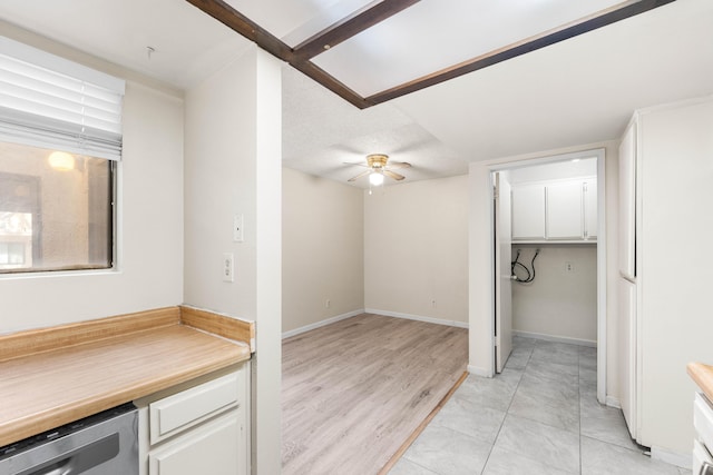 kitchen with light wood-type flooring, a textured ceiling, white cabinets, and ceiling fan