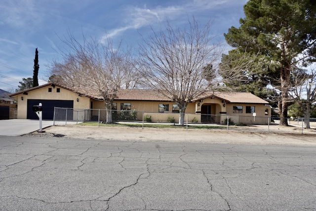 single story home with a fenced front yard, a tiled roof, concrete driveway, stucco siding, and an attached garage