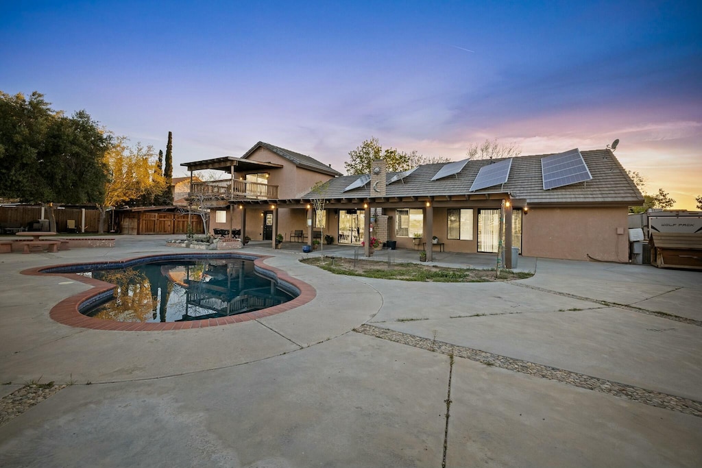 36070 E 43rd St, Palmdale, CA 93552 - rear view of house featuring a fenced backyard, stucco siding, a patio, solar panels, and a fenced in pool