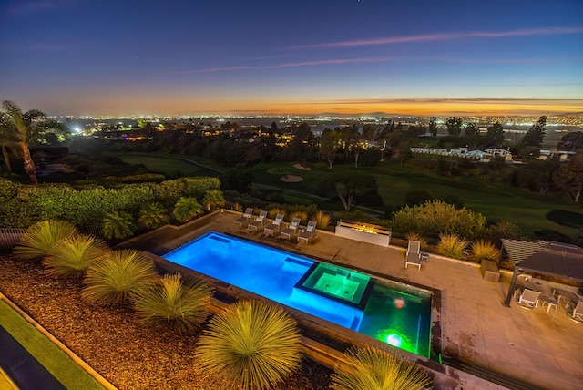 pool at dusk featuring a patio area