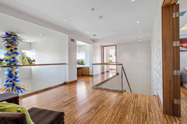 hallway with a wealth of natural light and light hardwood / wood-style flooring