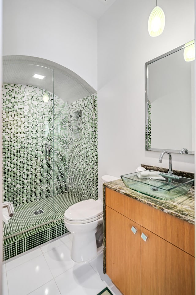 bathroom with tile patterned floors, vanity, walk in shower, and toilet