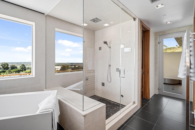 bathroom featuring tile patterned flooring, separate shower and tub, and tile walls