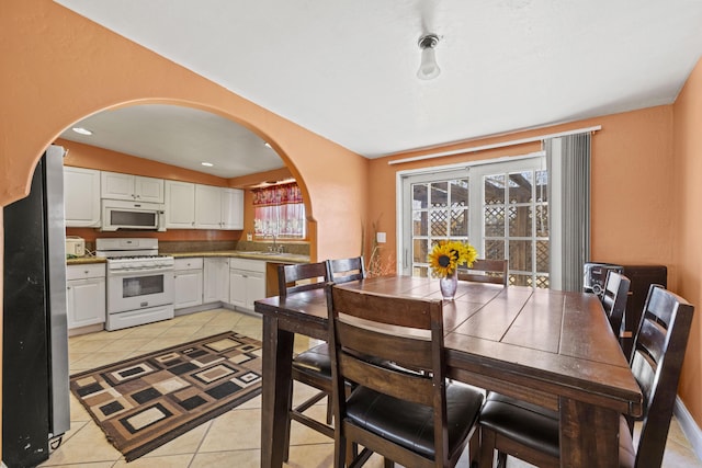 tiled dining room featuring sink