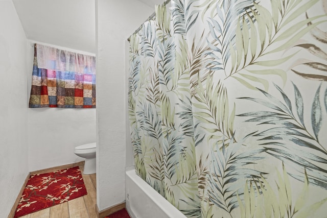 bathroom featuring baseboards, toilet, and wood finished floors