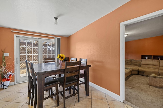 dining area featuring light tile patterned floors, a textured ceiling, and baseboards