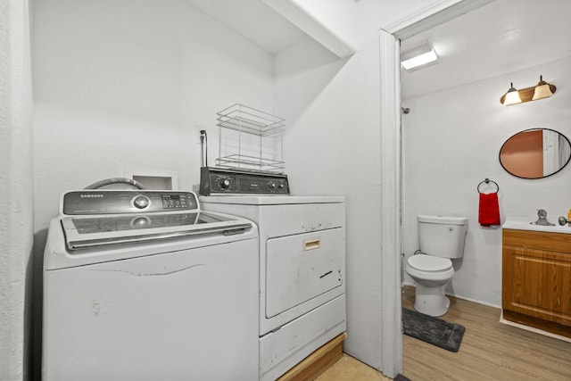 laundry room featuring laundry area, light wood finished floors, and independent washer and dryer