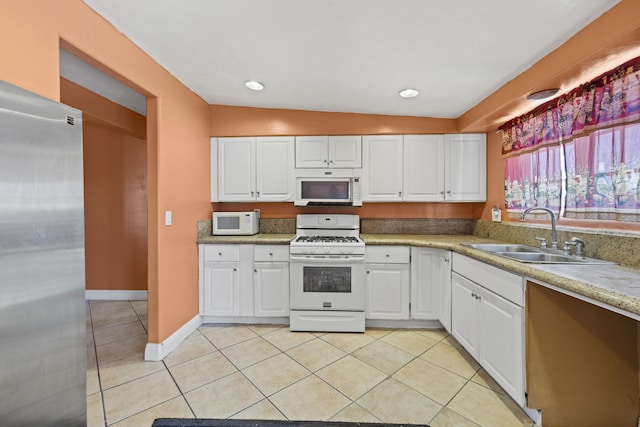 kitchen featuring vaulted ceiling, white cabinetry, sink, and white appliances