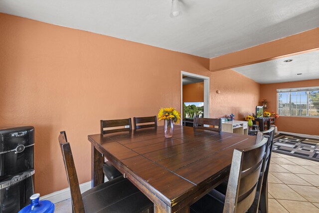 kitchen featuring lofted ceiling, light tile patterned floors, and stainless steel refrigerator with ice dispenser