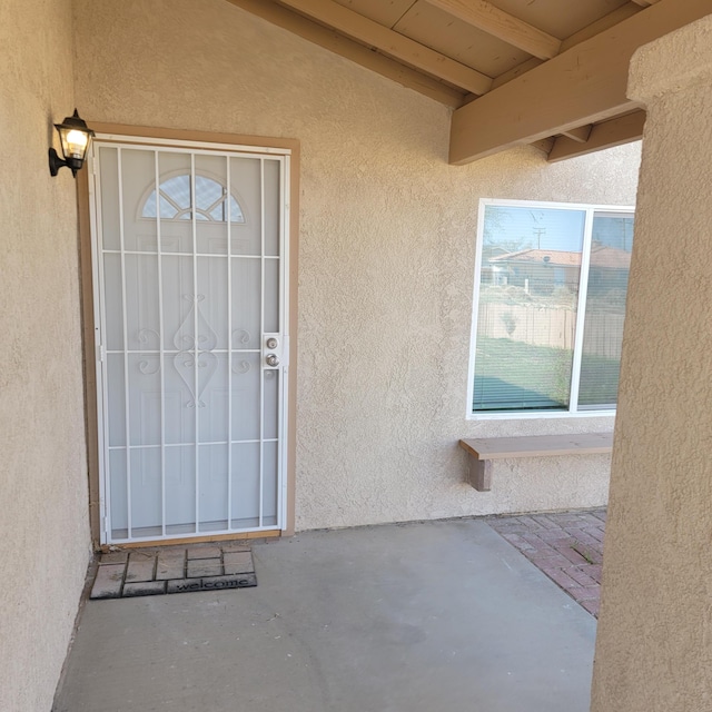 entrance to property featuring stucco siding