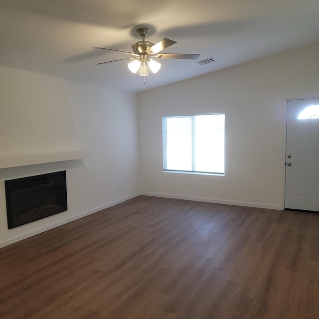 unfurnished living room with a ceiling fan, wood finished floors, a fireplace, and visible vents