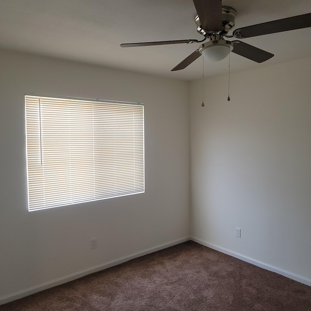 carpeted empty room featuring baseboards and ceiling fan
