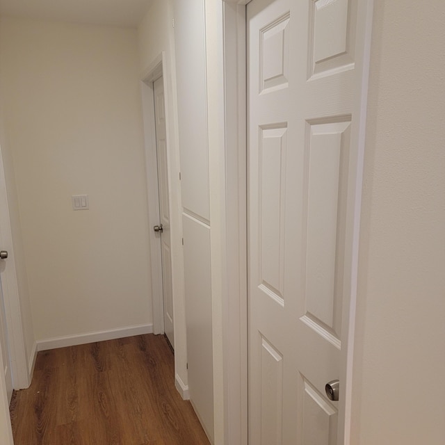 hallway with baseboards and wood finished floors