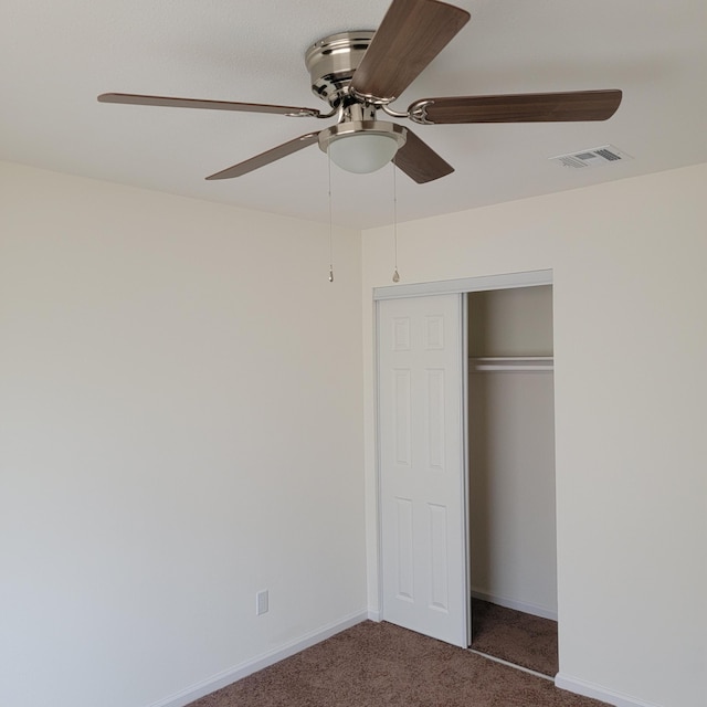 unfurnished bedroom with baseboards, carpet floors, visible vents, a ceiling fan, and a closet